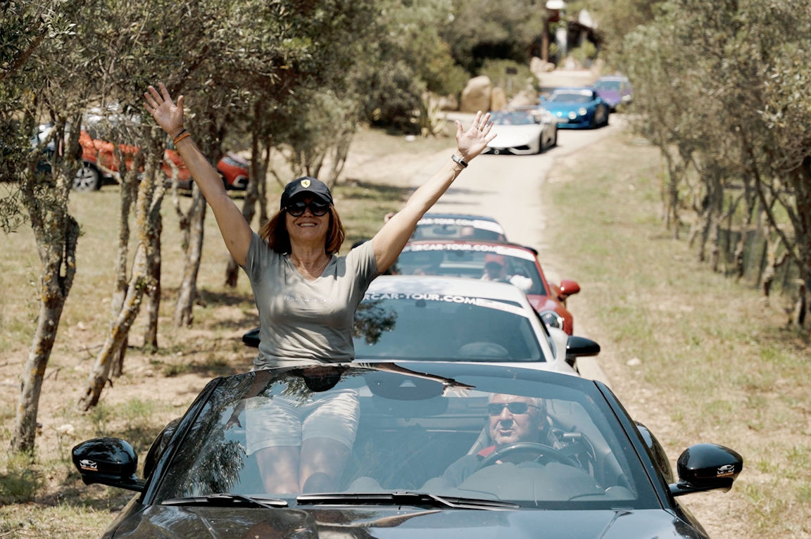Camargue : supercars - a woman sitting on top of a car with her hands up